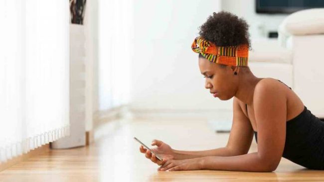 一位黑人女孩在使用手機思考